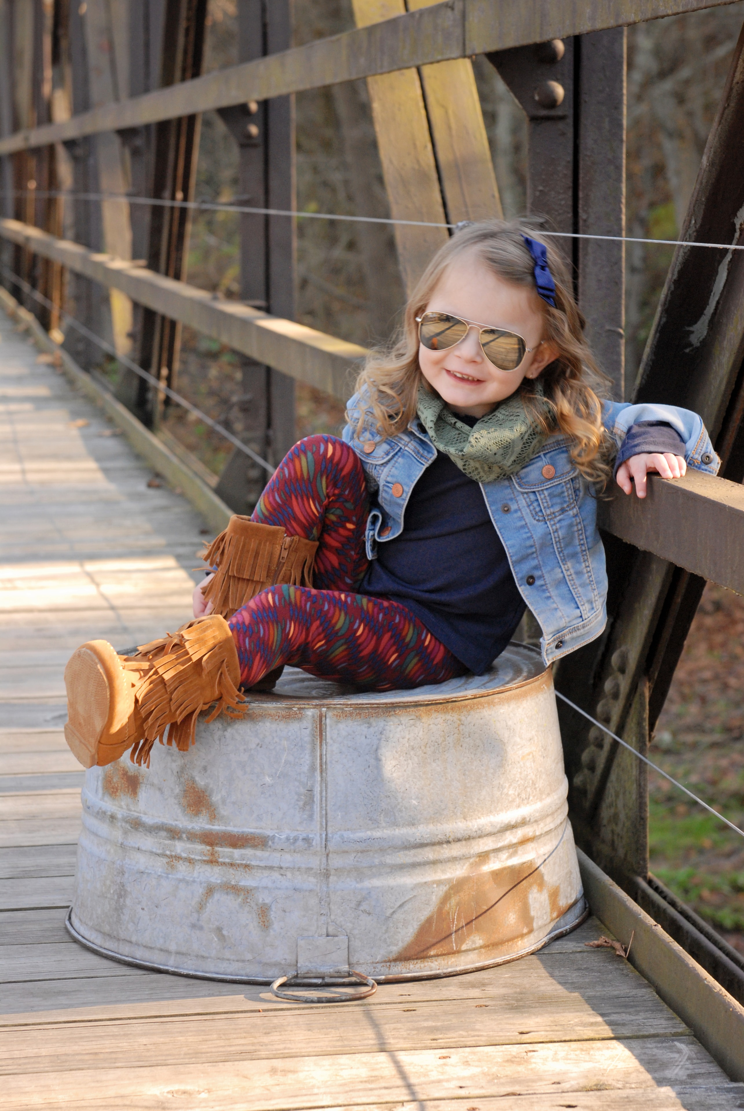 Young girl sitting in metal bucket smiling